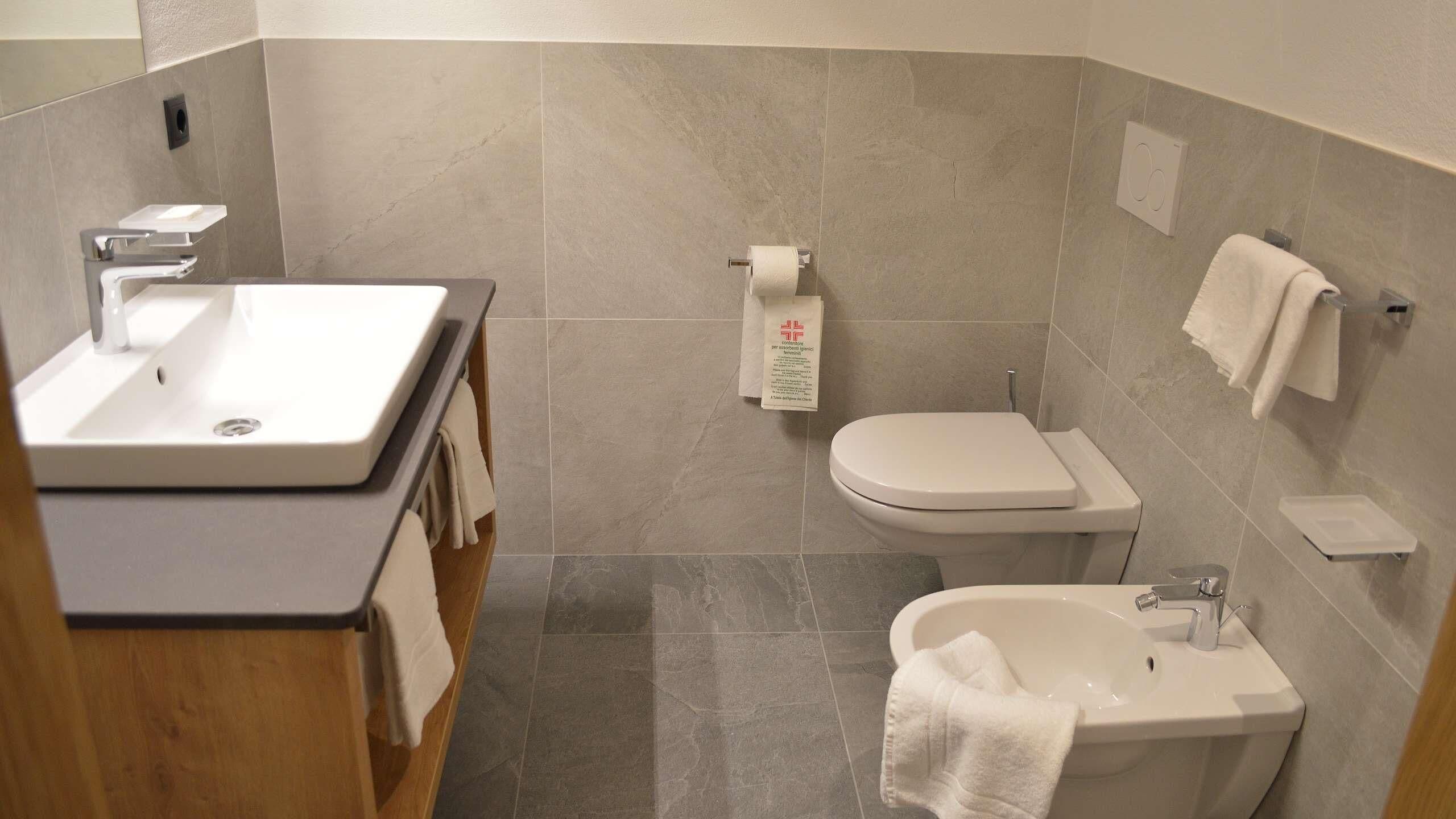 Un baño con lavamanos, inodoro y bidé.