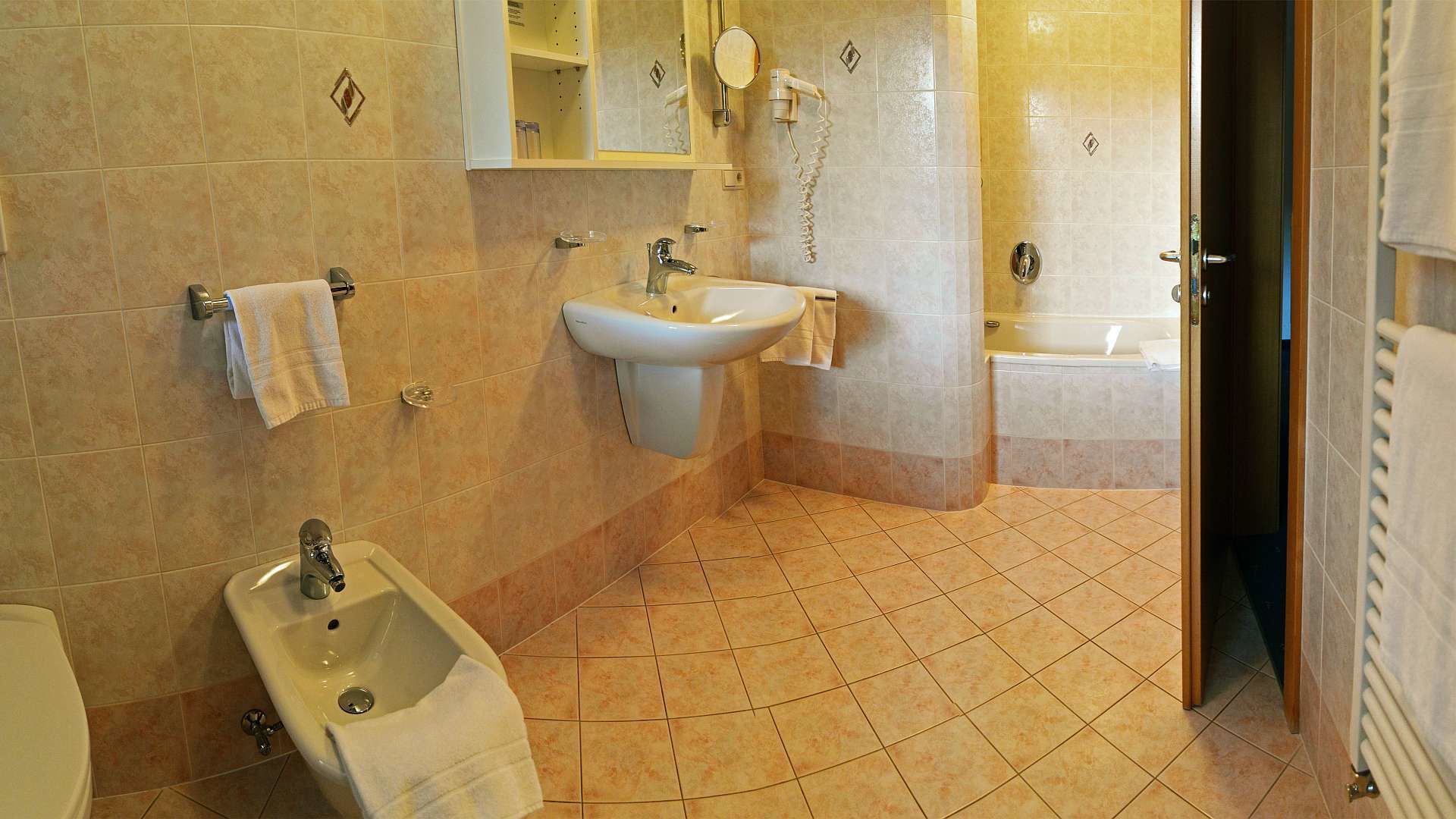 Casa de banho com bidé, pia e banheira.