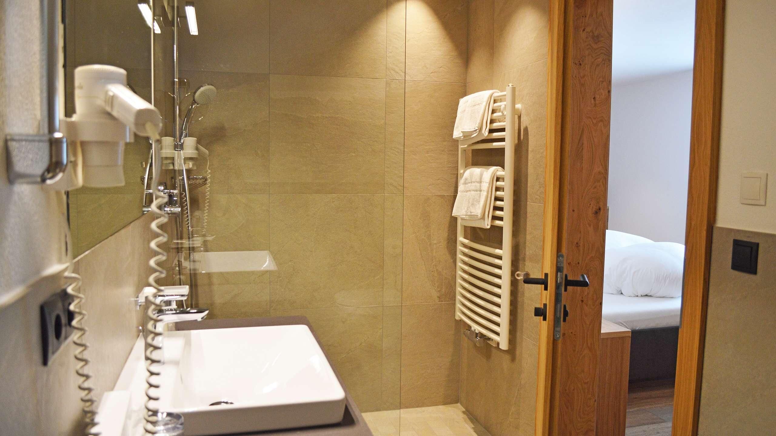 A bathroom with a sink, mirror, and towel rack.