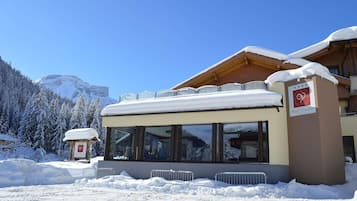 Ein Hotel mit verschneitem Dach und Bergblick.