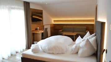 A modern hotel room with a large bed, a seating area, and a wooden wall.