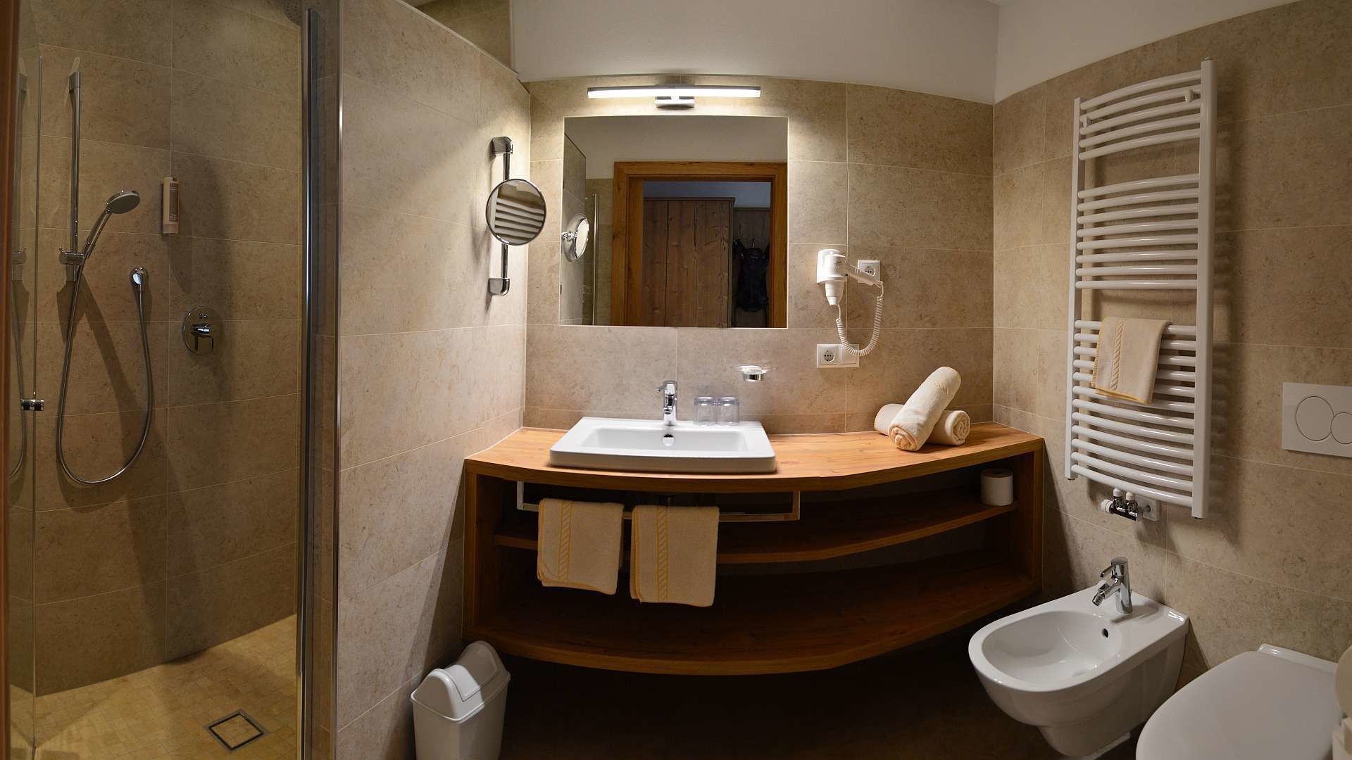 Un baño moderno con ducha, lavabo, bidé y espejo.
