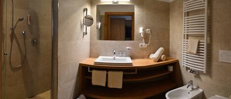 Un baño moderno con ducha, lavabo, bidé y espejo.