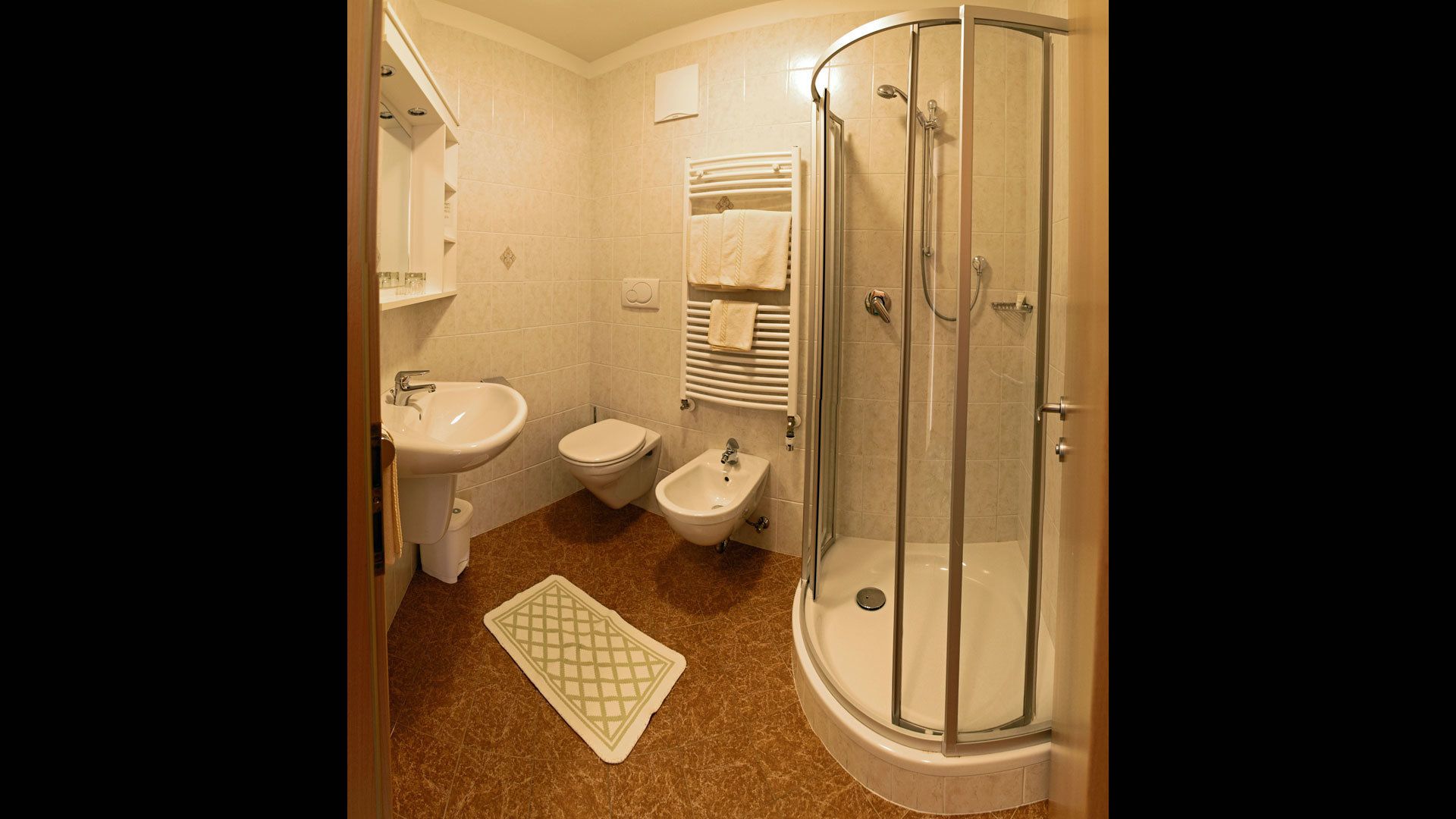Un baño con ducha, bidé, inodoro y lavabo.
