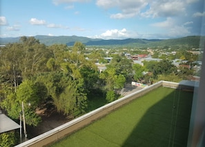 A view from a window overlooking a grassy area with trees and a distant town. - City Express by Marriott Esteli (Esteli)