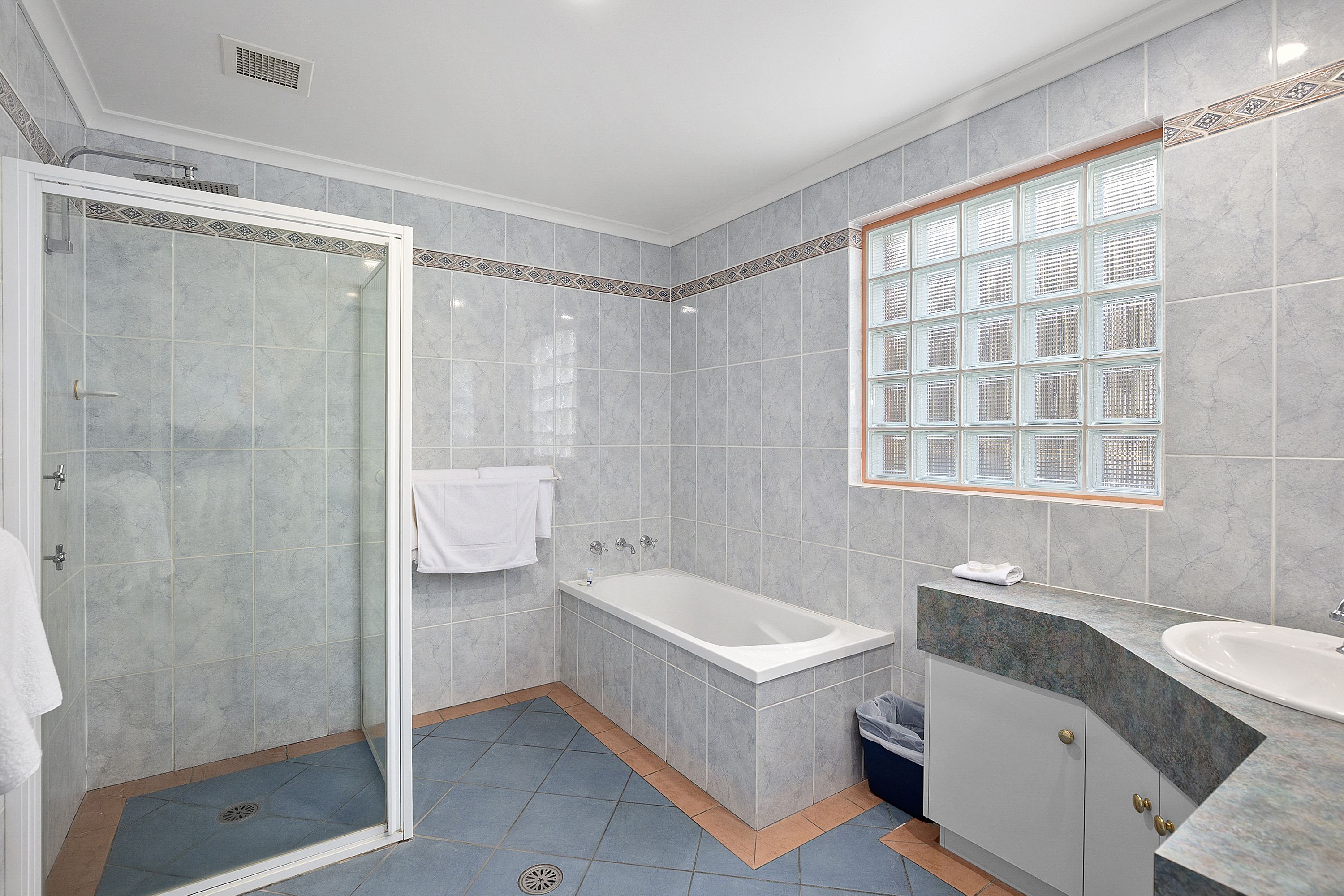 A modern bathroom with a glass-enclosed shower, a freestanding bathtub, and a vanity with a sink.