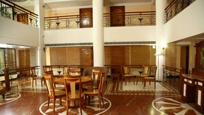 A spacious lobby with a high ceiling, multiple seating areas, and a decorative floor pattern. - Mayura Residency (Chavakkad)
