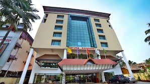 A multi-story hotel with a prominent entrance, a glass facade, and a red-tiled roof. - Mayura Residency (Chavakkad)