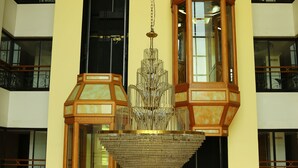 A building with a large, ornate chandelier hanging between two hexagonal lanterns. - Mayura Residency (Chavakkad)