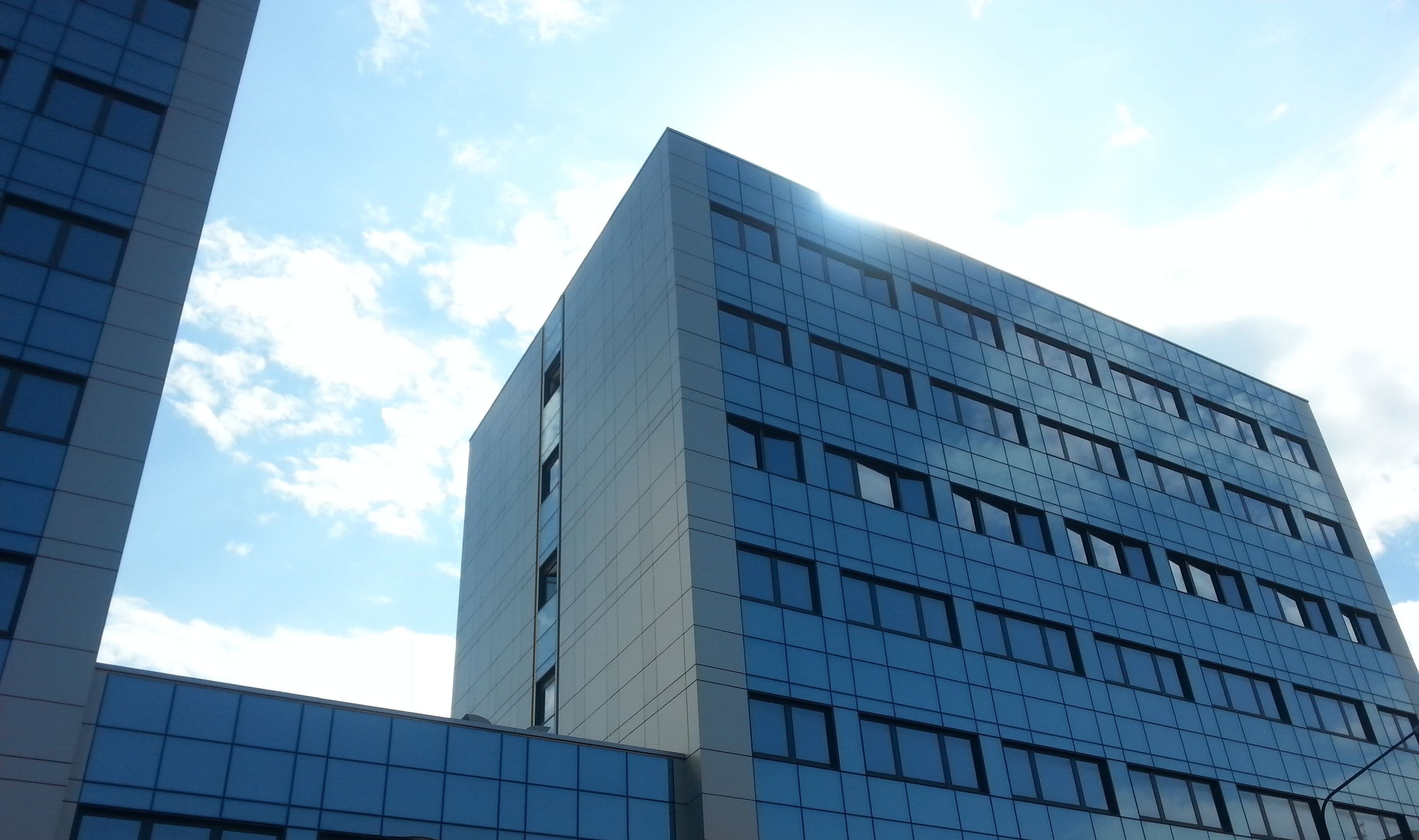 A modern building with a glass facade and multiple windows.
