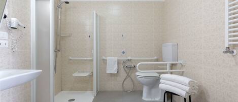 A modern bathroom with a shower, toilet, sink, and a bidet.