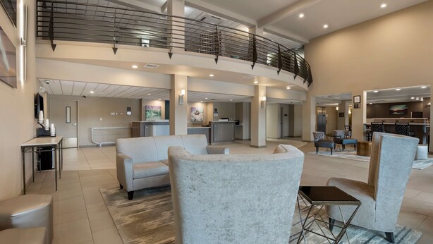 A spacious lobby with a high ceiling, a staircase, and a reception desk. - Best Western Plus Chena River Lodge (Fairbanks)