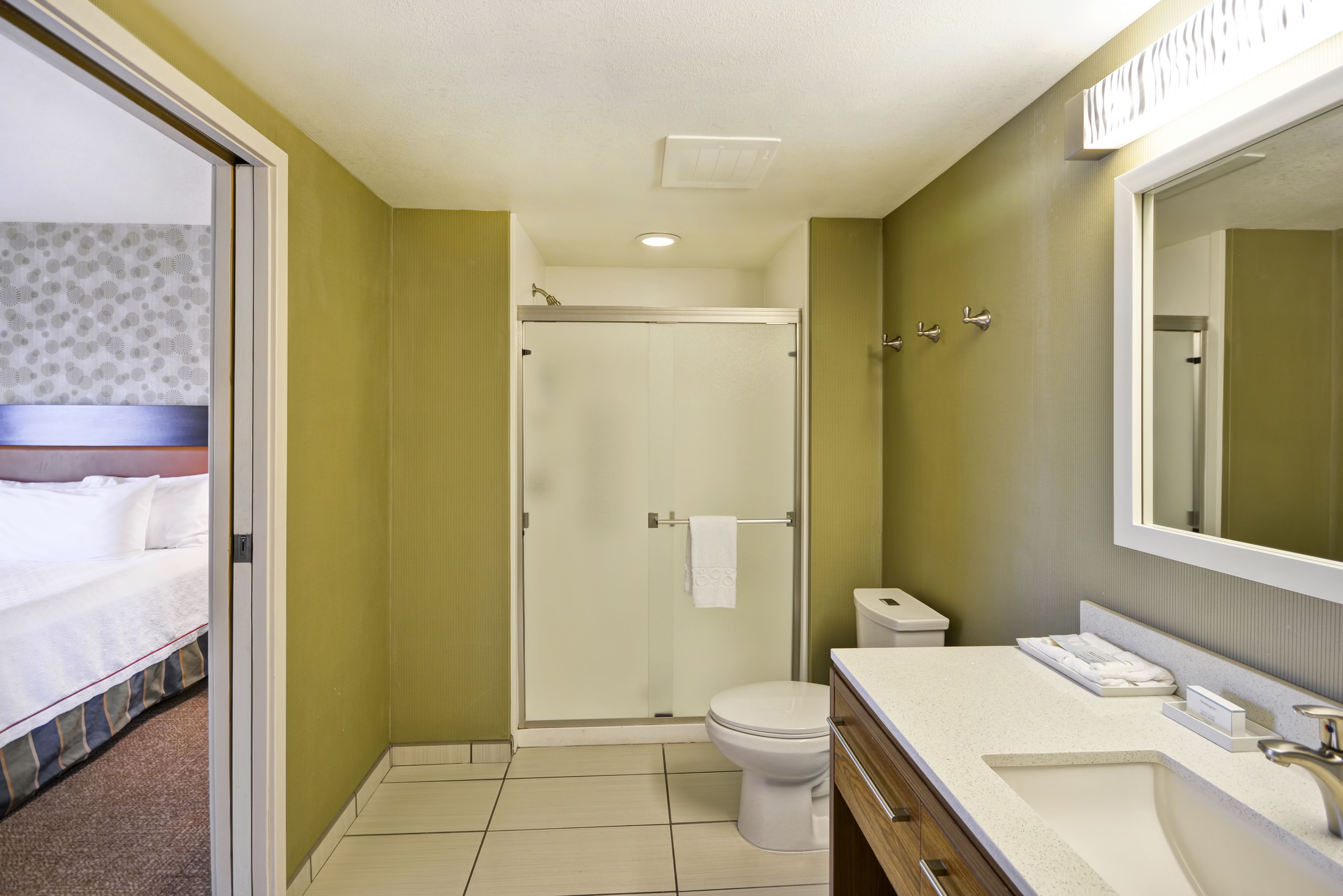 A hotel bathroom with a shower, toilet, and sink.