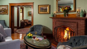 A cozy living room with a fireplace, comfortable seating, and a dining area.