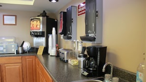 A kitchen with a coffee maker, toaster, and sink.