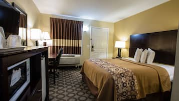 A hotel room with a bed, desk, and chair.