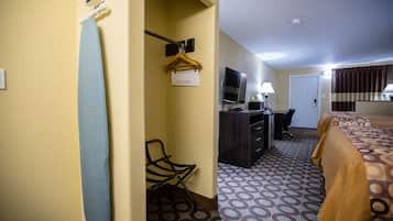 Une chambre d’hôtel avec un lit, un bureau avec un ordinateur, une télévision et une chaise.