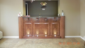 A reception area with a wooden counter, a fan, and a small decorative item on top.