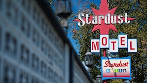 Un letrero de motel con el nombre 'Stardust Motel' y un diseño de estrella roja.