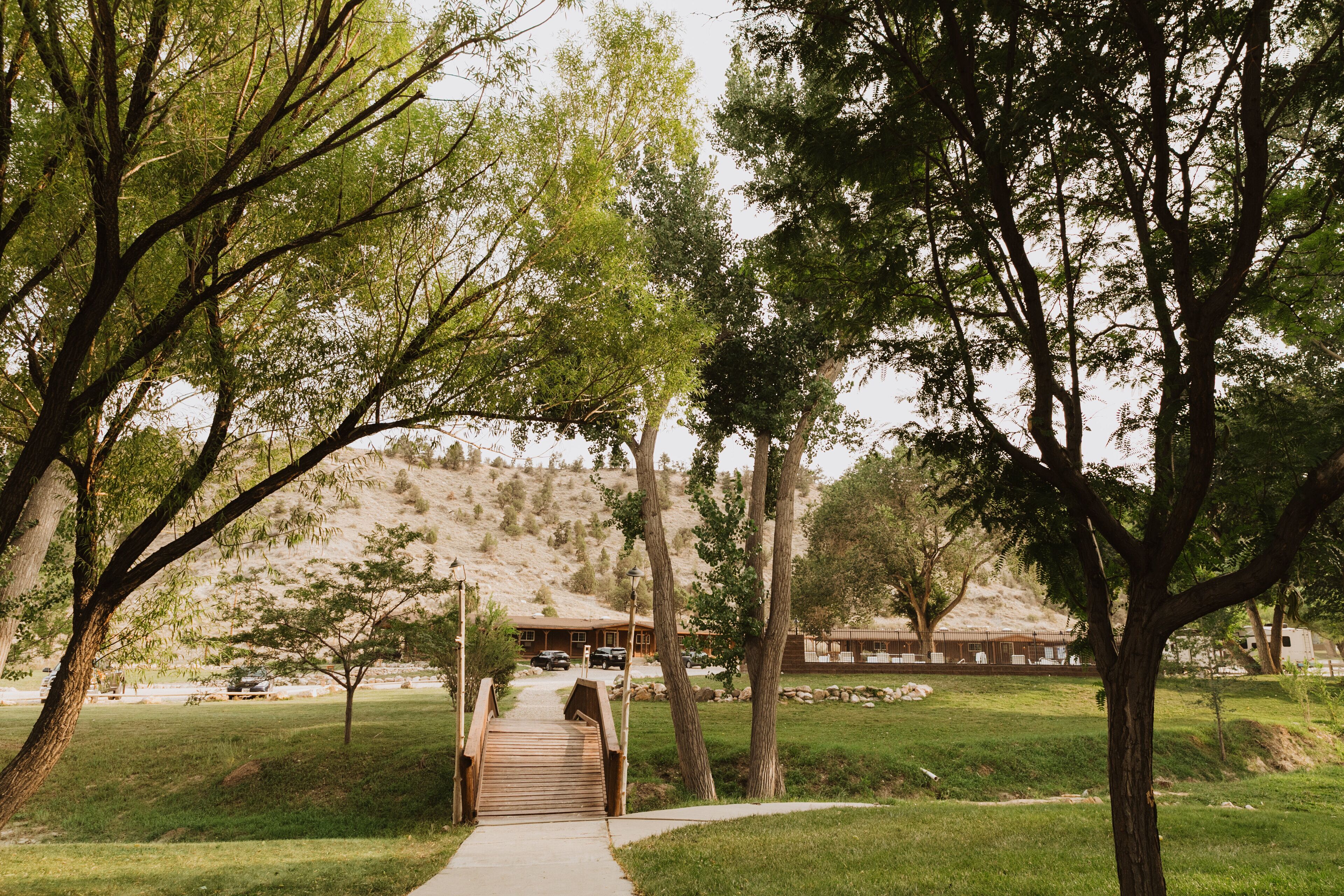 A pathway leading to a building surrounded by trees and a grassy area.