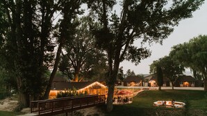 A park with a wooden bridge, picnic tables, and a fire pit area. - Bryce Pioneer Village (Tropic)