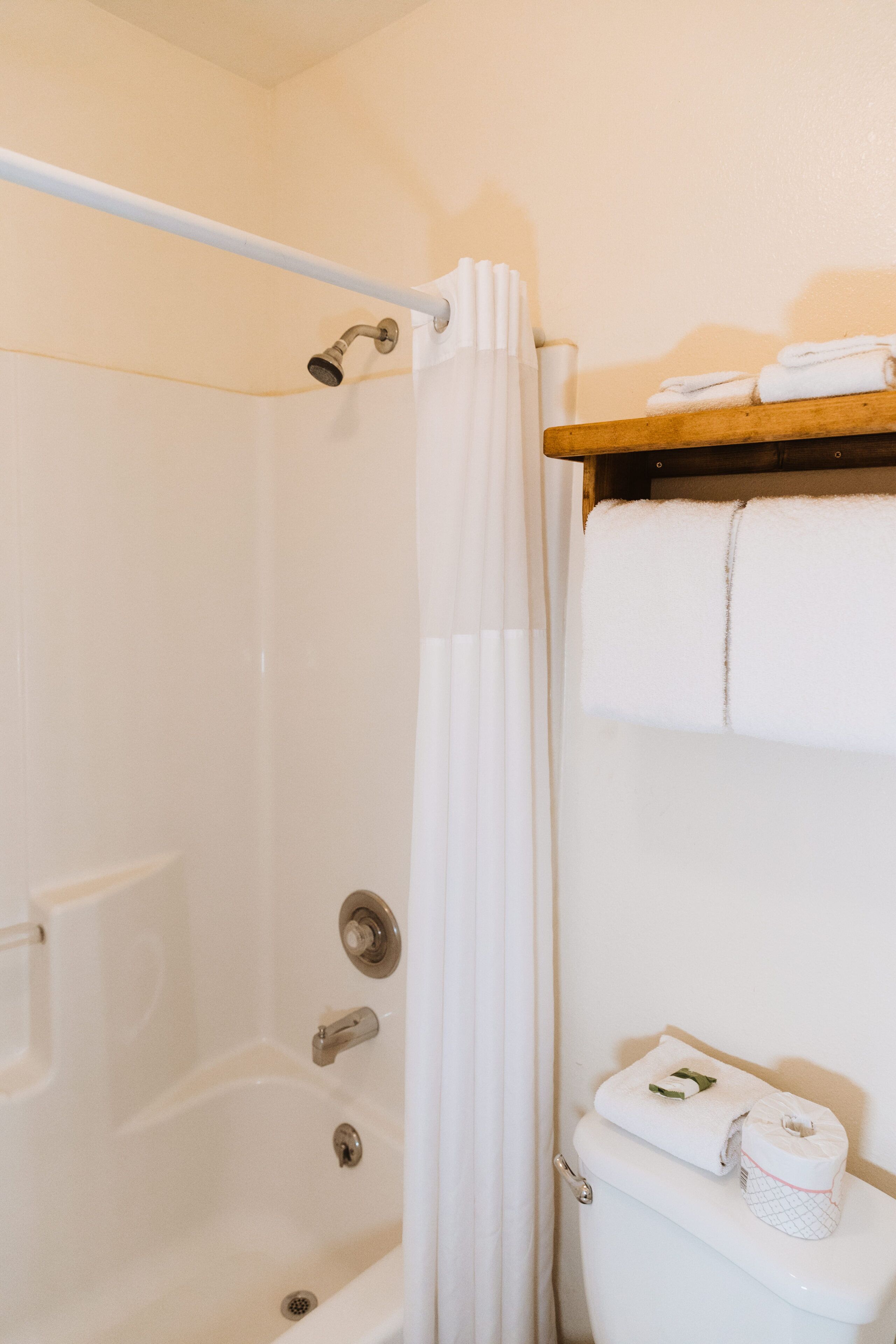 Ein Badezimmer mit Badewanne, Toilette und einem Handtuchregal.