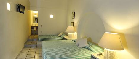 A hotel room with two beds, a bathroom, and a staircase.