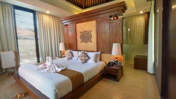 A large bed with a wooden headboard, two bedside tables with lamps, a large mirror, and a towel on the bed.