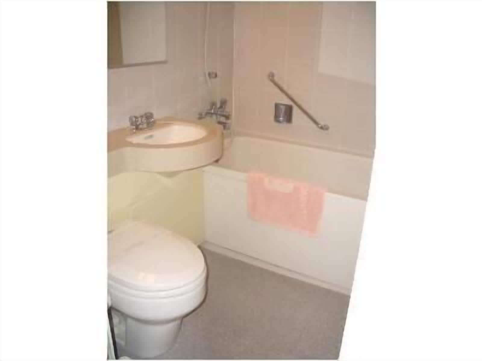 A bathroom with a toilet, sink, and bathtub.