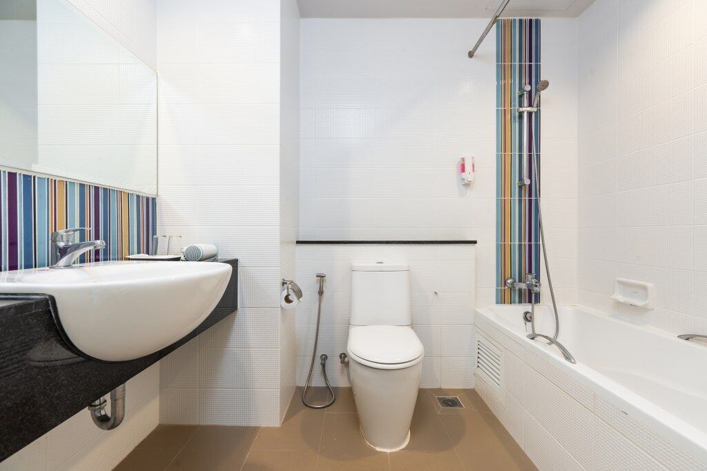 A modern bathroom with a white sink, toilet, and bathtub.
