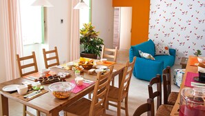 A dining area with a wooden table set for a meal, surrounded by chairs.