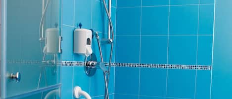 A bathroom with blue tiles, a white sink, and a shower area.