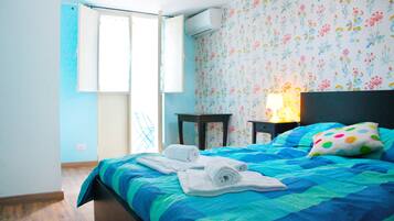 Una camera da letto con un letto, un comodino, una lampada e una finestra con tende.