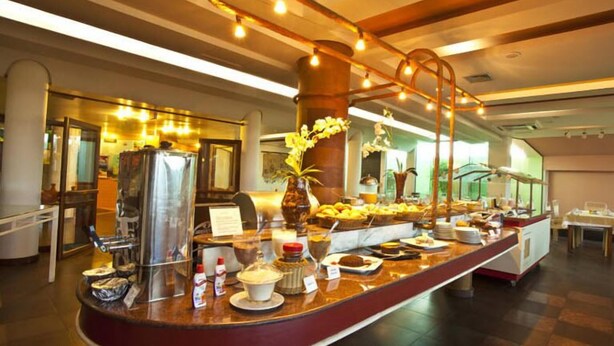 A buffet setup with various food items and condiments. - Ingleses Express (Florianopolis)