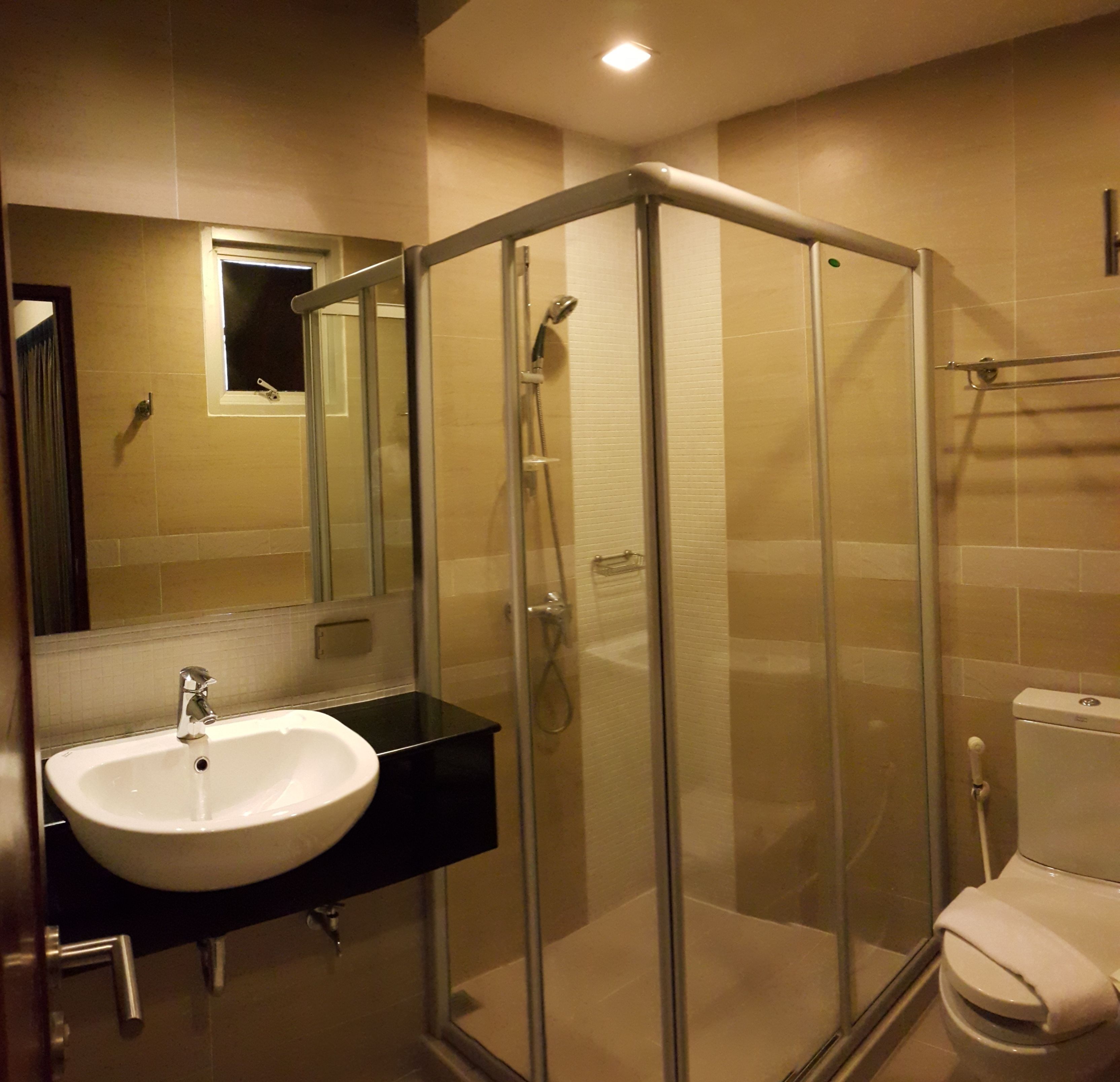 Un bagno moderno con doccia vetrata, lavabo e WC.