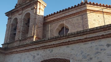 Een historisch gebouw met een klokkentoren, gebogen ramen en een pannendak.