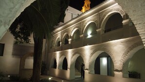 A building with multiple arches and a tower at the end. - Hotel Convento Aracena & Spa (Aracena)