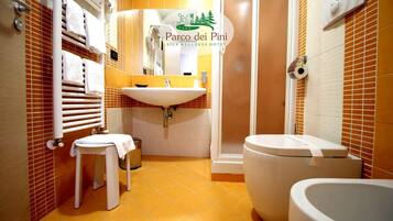 A bathroom with a sink, toilet, and a small stool.