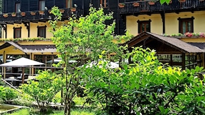 A hotel with multiple balconies, outdoor seating, and lush greenery.
