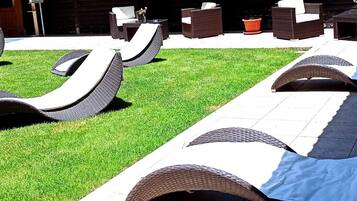 Outdoor lounge chairs with a unique curved design, arranged on a well-maintained lawn.