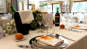 A dining table set for a meal with a menu, wine bottle, and glasses.