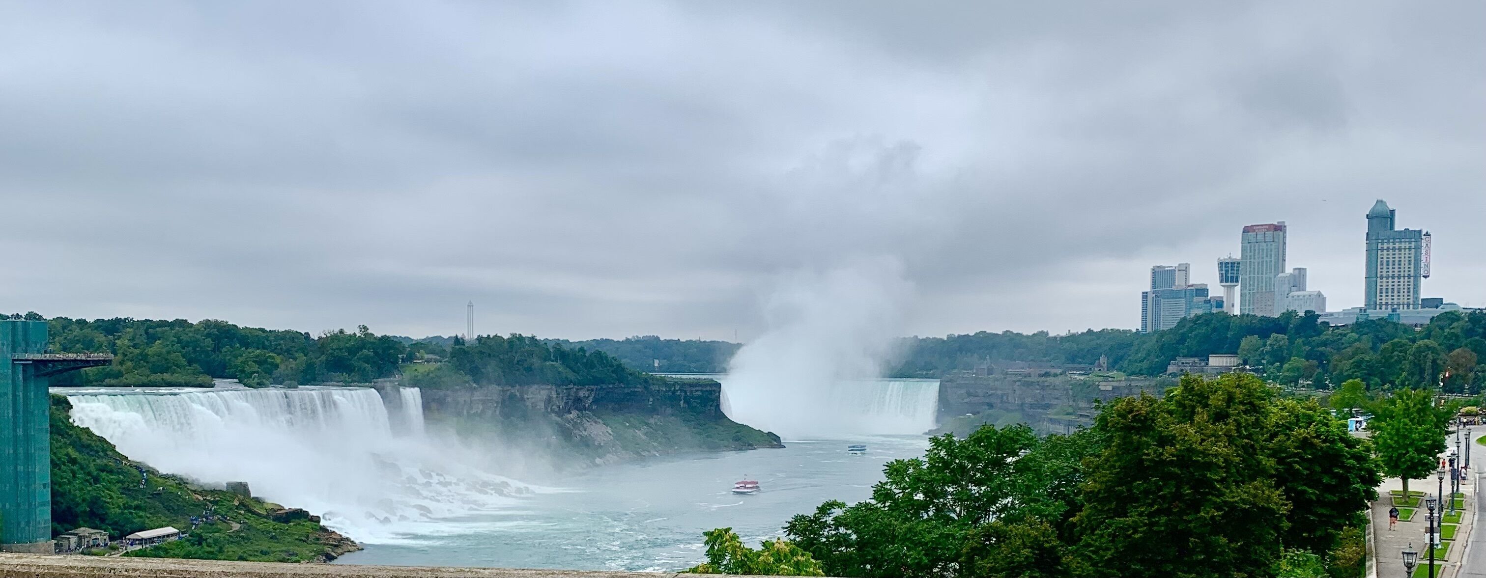 A large waterfall with a cityscape in the background.