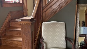 A wooden staircase with a chair at the bottom. - The Red Coat Bed & Breakfast (Niagara-on-the-Lake)