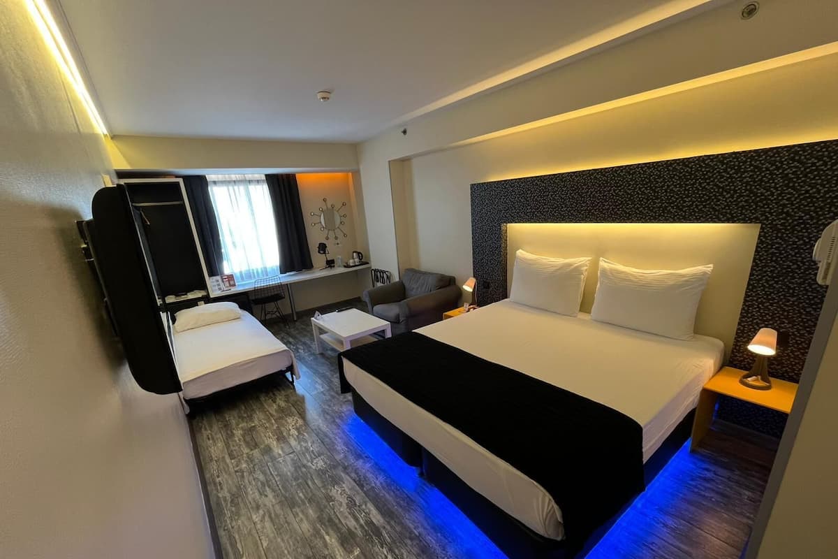 Een moderne hotelkamer met een groot bed, een bureau, een stoel en een televisie.