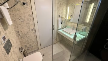 Un baño con inodoro, lavamanos y zona de ducha.