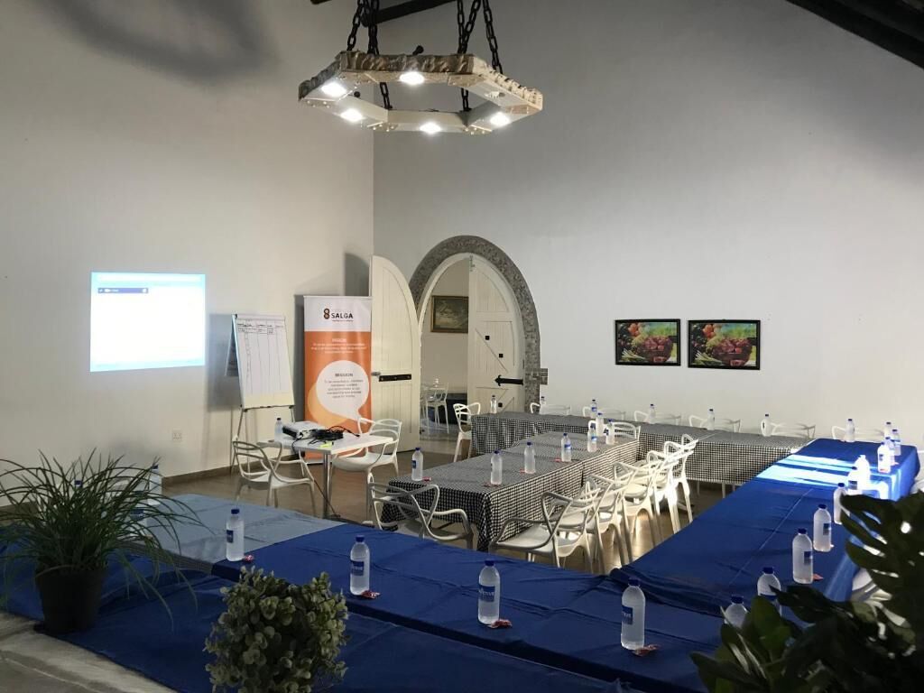 A conference room with a long table, chairs, a projector screen, and a whiteboard.