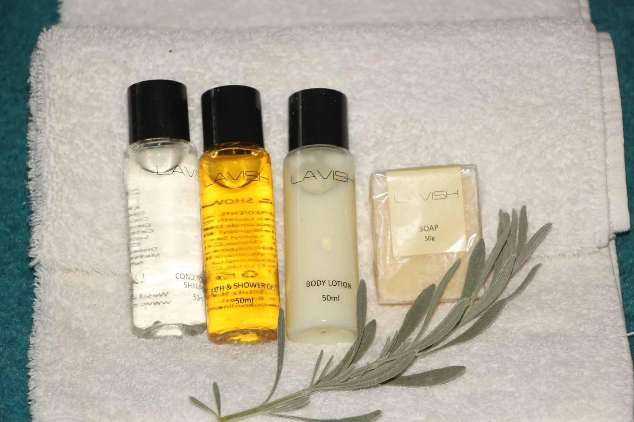 A set of four personal care products on a white towel.