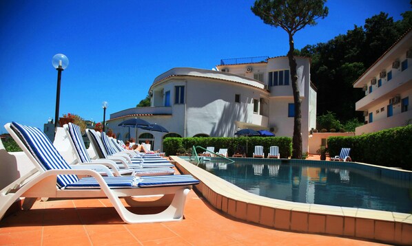 Alberca al aire libre y camastros 