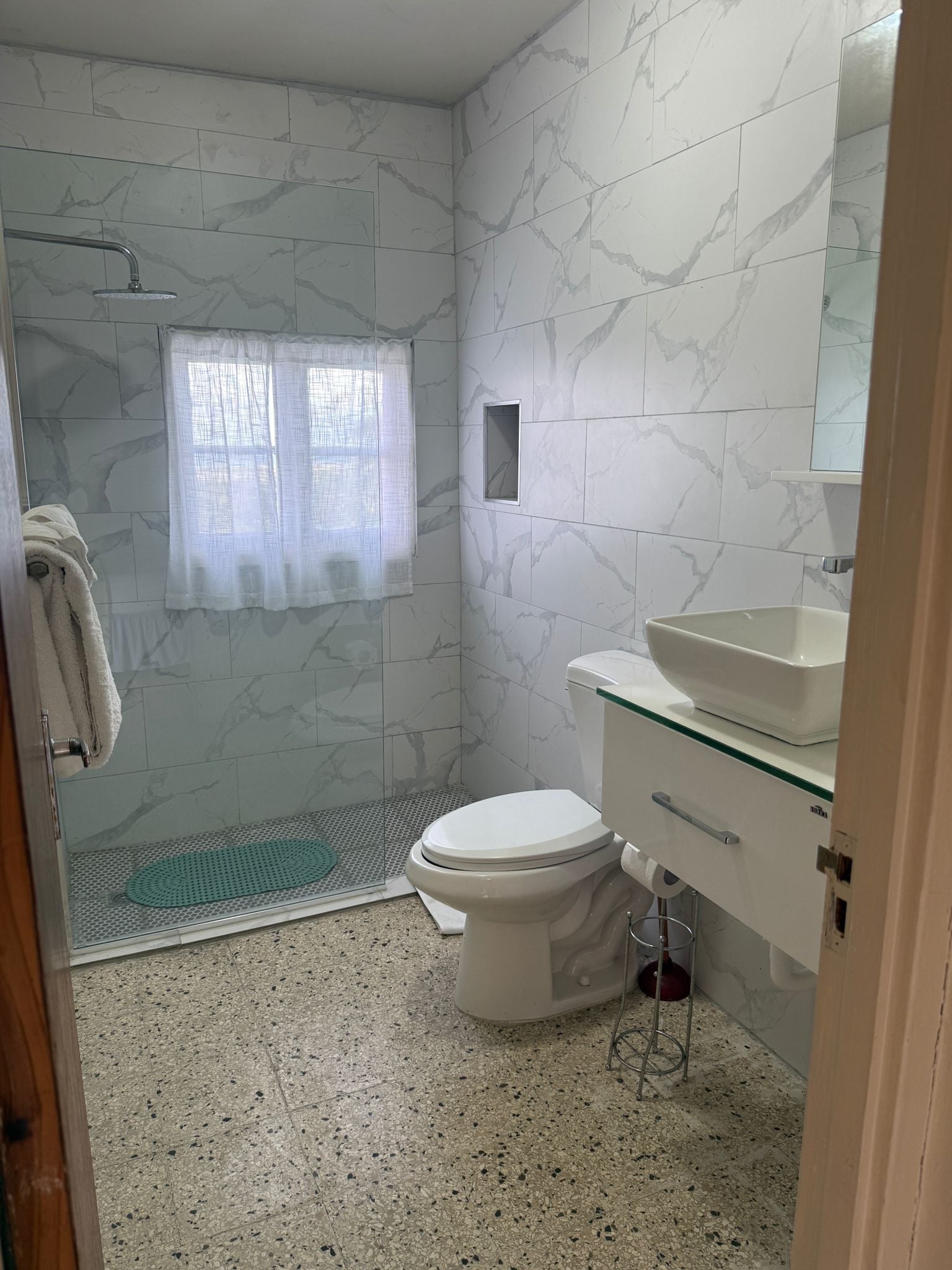 Un baño con ducha, inodoro y lavamanos.