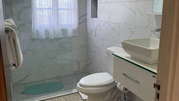 Un baño con ducha, inodoro y lavamanos.